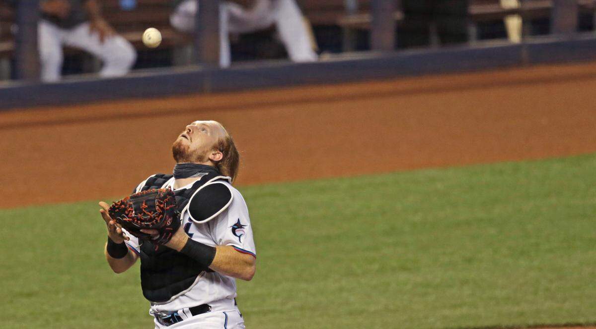 Miami Marlins catcher Chad Wallach (17) makes a catch on a foul ball by Boston Red Sox catcher Kevin Plawecki (25) during the first inning of a baseball game at at Marlins Park in Miami on Thursday, September 17, 2020.