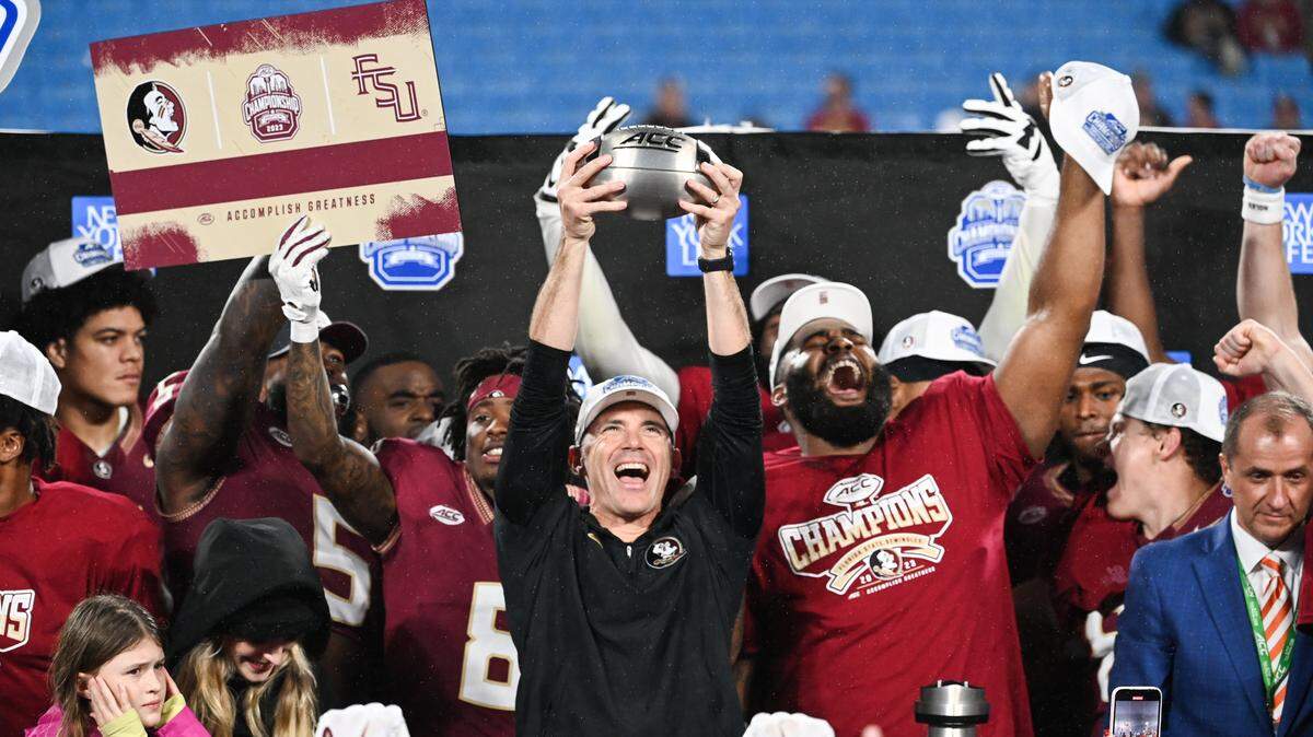 Dec 2, 2023; Charlotte, NC, USA; Florida State Seminoles head coach Mike Norvell raises the ACC Championship trophy with his players after the game against the Louisville Cardinals at Bank of America Stadium. Mandatory Credit: Bob Donnan-USA TODAY Sports