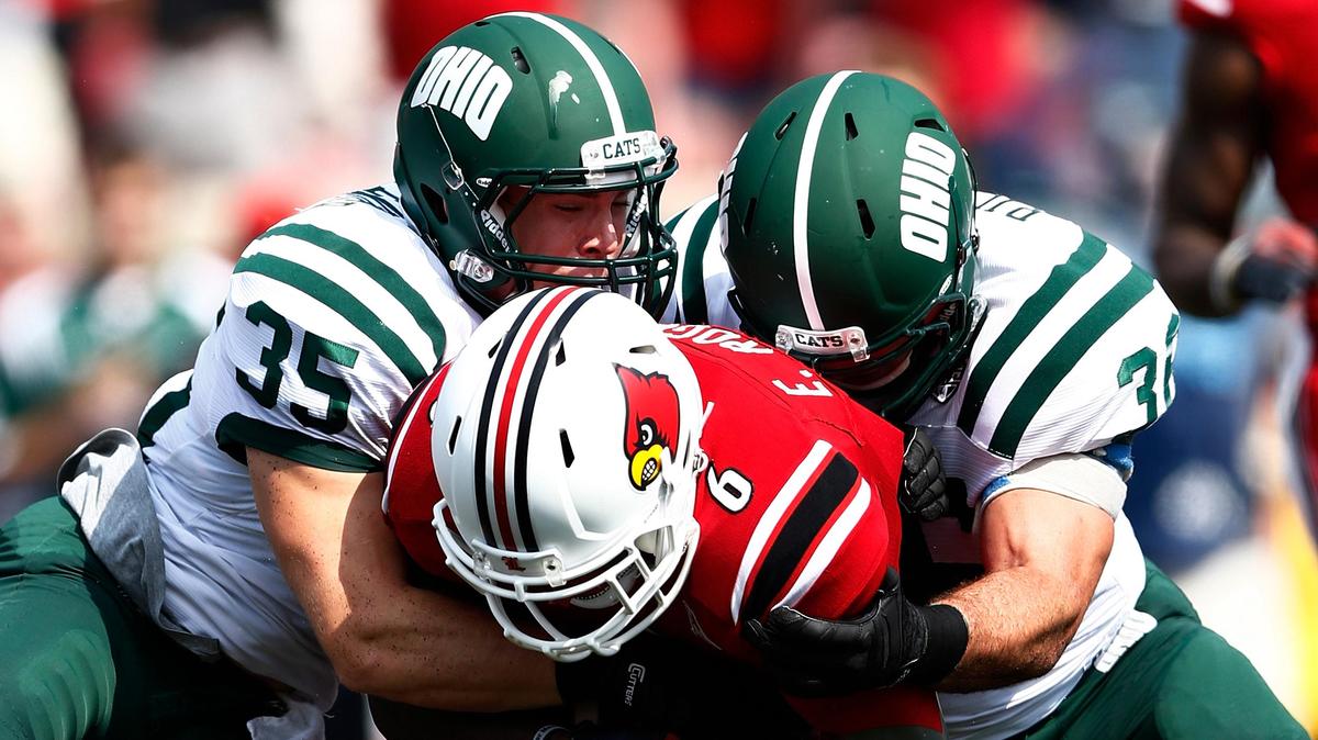 Quentin Poling, No. 32, and Nathan Carpenter, No. 35, of the Ohio Bobcats make a tackle against Eli Rogers, No. 6, of the Louisville Cardinals during the game at Papa John's Cardinal Stadium on September 1, 2013, in Louisville, Kentucky. Louisville won 49-7.