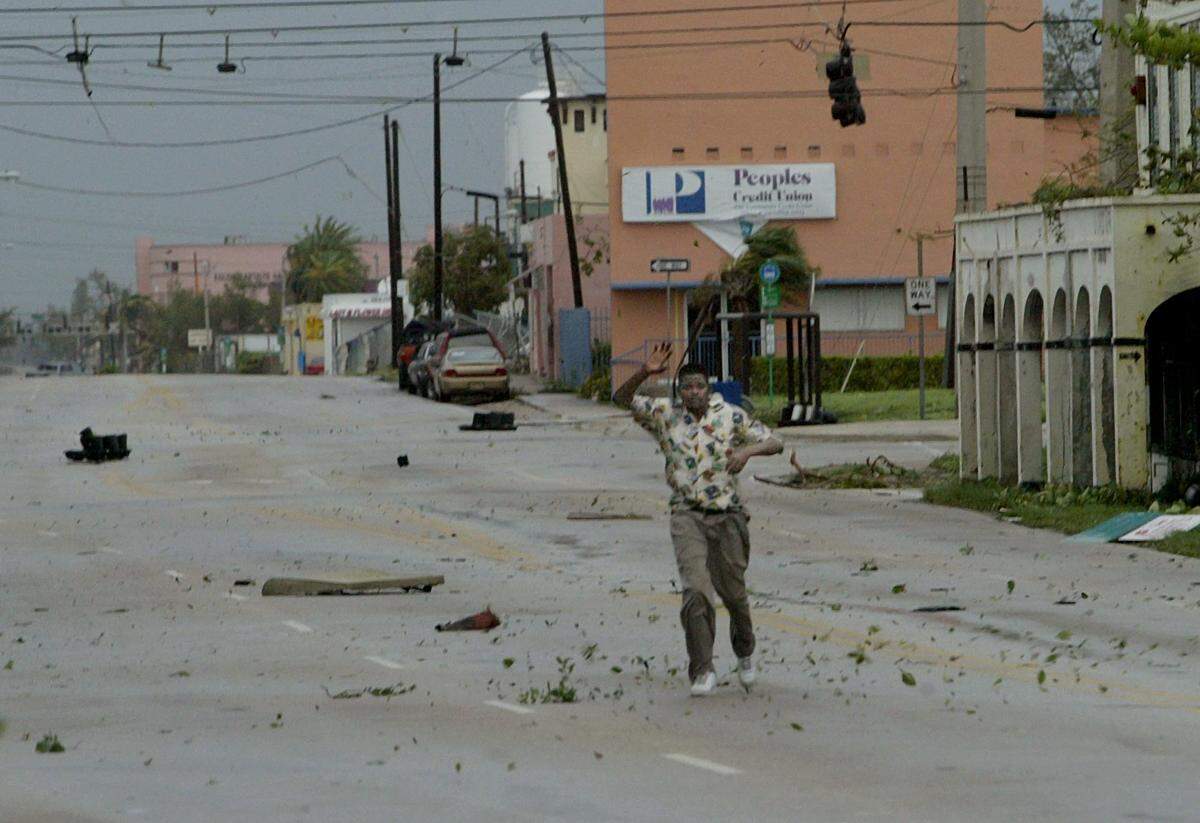 A man makes his way down Northeast Second Avenue near 62nd Street in Miami during Hurricane Wilma.