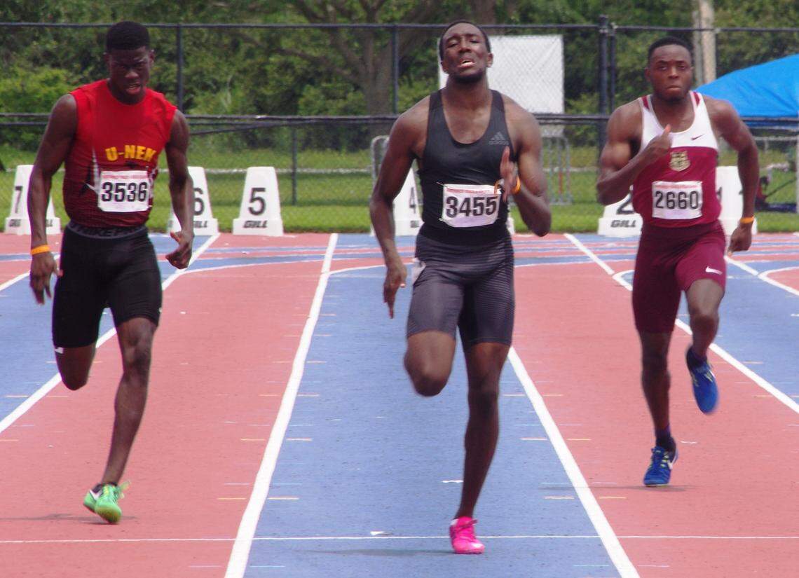 Three runners strain approaching the finish line at the Northwest Express Track Meet's final day.