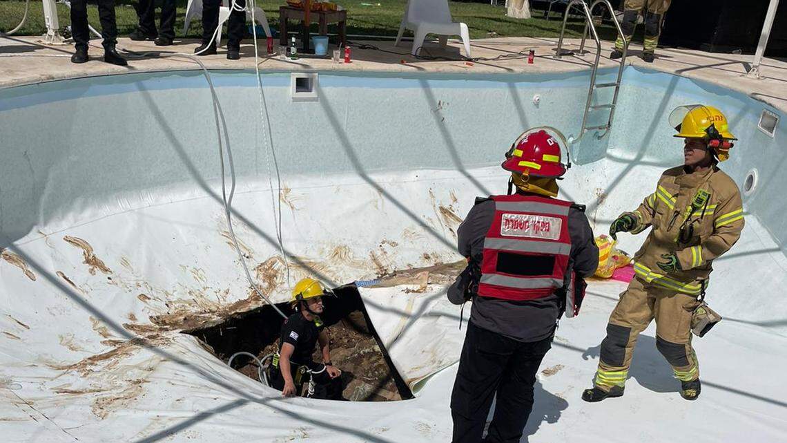 A sinkhole suddenly emerged at a company pool party in central Israel and sucked in two men. Rescue crews feared the sinkhole would collapse further.