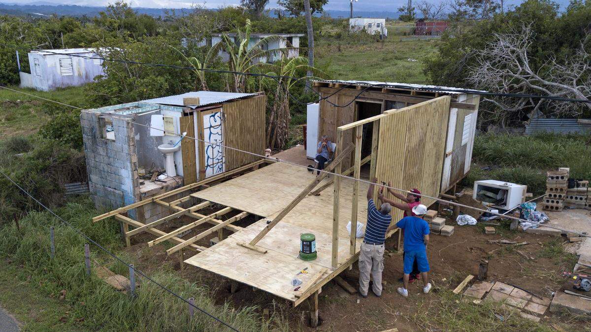 Lidia Reyes sits as she watches family members rebuild her home one year after Hurricane Maria destroyed her house in Barrio Islote, Arecibo in Puerto Rico on Friday, August 24, 2018.
