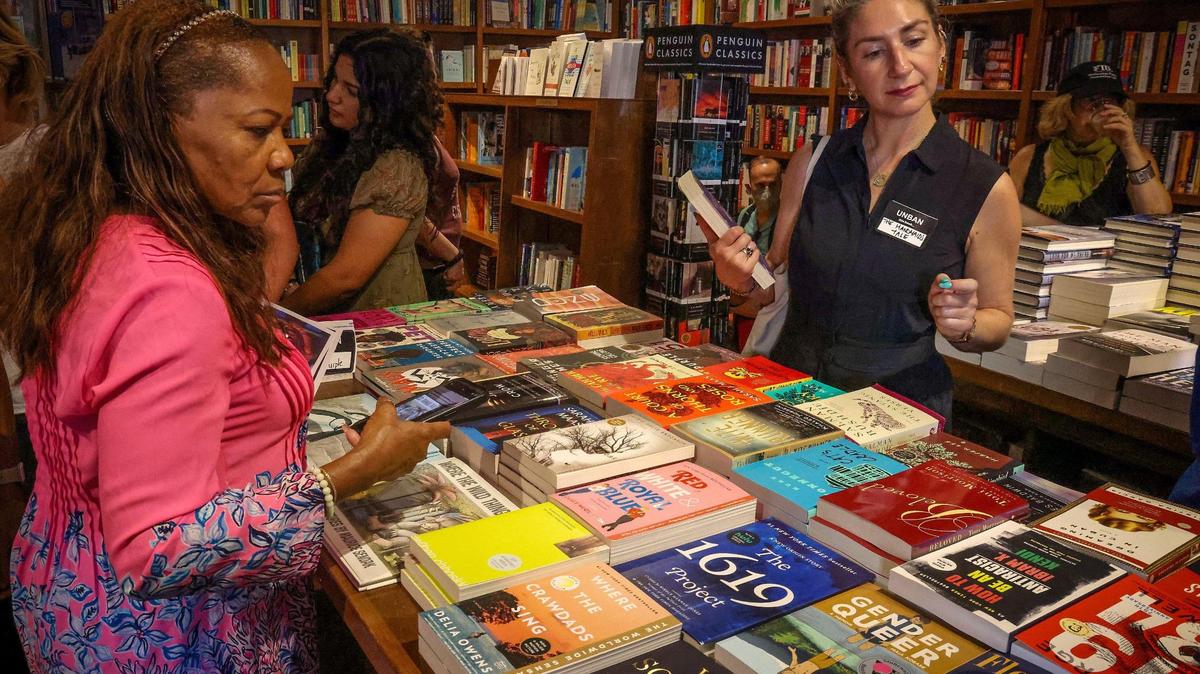 Educator Nancy St. Leger, left, and author Rebekah Shoaf, right, check out some of the banned books displayed during the “Walk for Freadom” kickoff event Oct. 1, 2023 in Coral Gables
