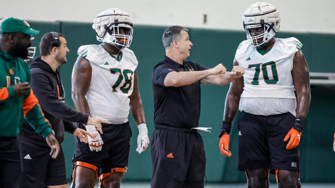 Miami Hurricanes head coach Mario Cristobal speaks with offensive tackle Markel Bell (70) during practice at the Carol Soffer Indoor Practice Facility in Coral Gables, Florida on Wednesday, March 6, 2024.