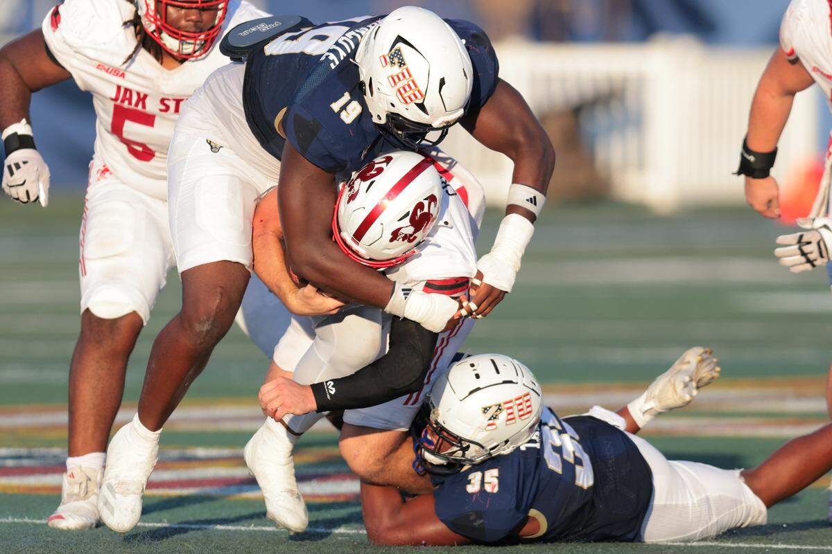 FIU Panthers defensive tackle Olasunkonmi Agunloye (19) and linebacker Josiah Taylor (35) sack Jacksonville State Gamecocks quarterback Caden Creel (12) during the second quarter at Pitbull Stadium on Saturday, Nov. 22, in Miami, Fla.