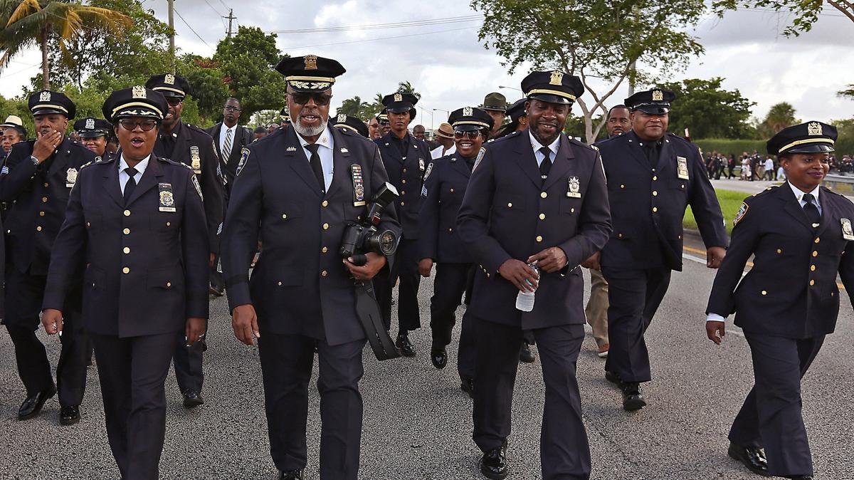 Law enforcement officers and members of NOBLE (National Organization of Black Law Enforcement) from around the country participate in a march from Calder Racetrack and Casino to Antioch Missionary Baptist Church in Miami Gardens on Wednesday, Aug. 1, 2018, for discussions regarding the shooting deaths and reducing gun violence in Miami Gardens.
