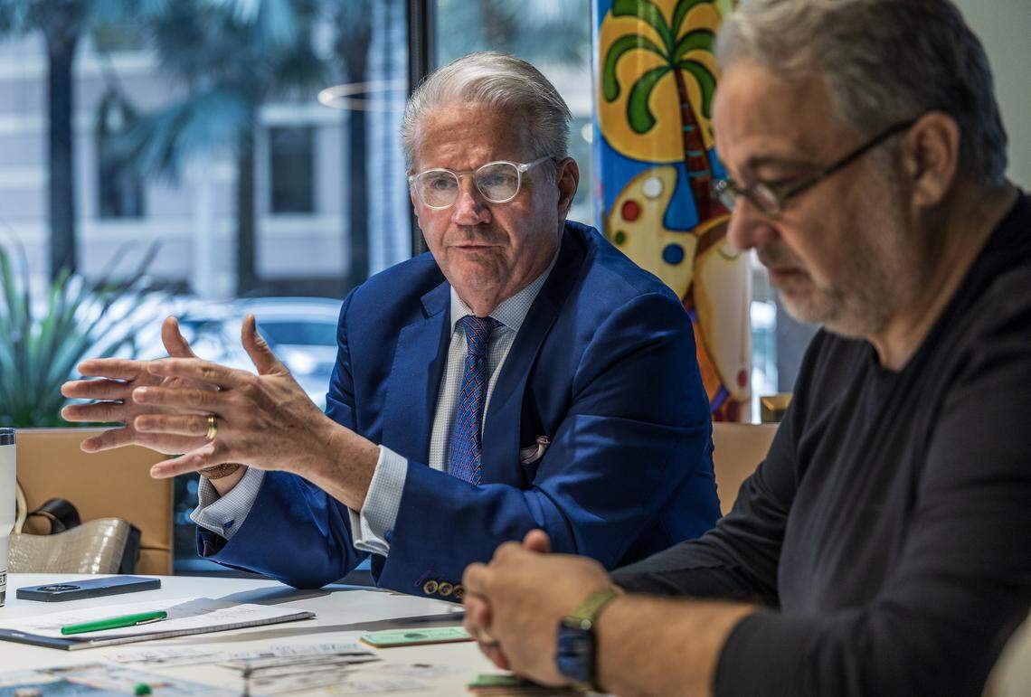 Eddy Martinez (right), owner of the BLISS Imprints & Gifts store, listen as Jorge L. Arrizurieta, President of the Coral Gables Chamber of Commerce, as they play the Gables-Opoly, a Coral Gables-themed Monopoly-style game, during a meeting at the Coral Gables Chamber of Commerce, on Tuesday, March 17, 2026.
