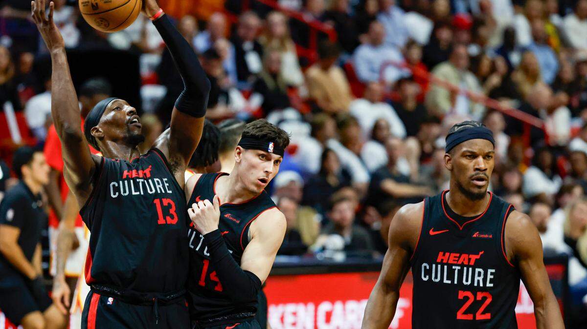 Miami Heat center Bam Adebayo (13) rebounds the ball as Miami Heat guard Tyler Herro (14) and Miami Heat forward Jimmy Butler (22) react to a call by the official during the game Atlanta Hawks in the first half at the Kaseya Center in Miami, Florida on Friday, January 19, 2024.