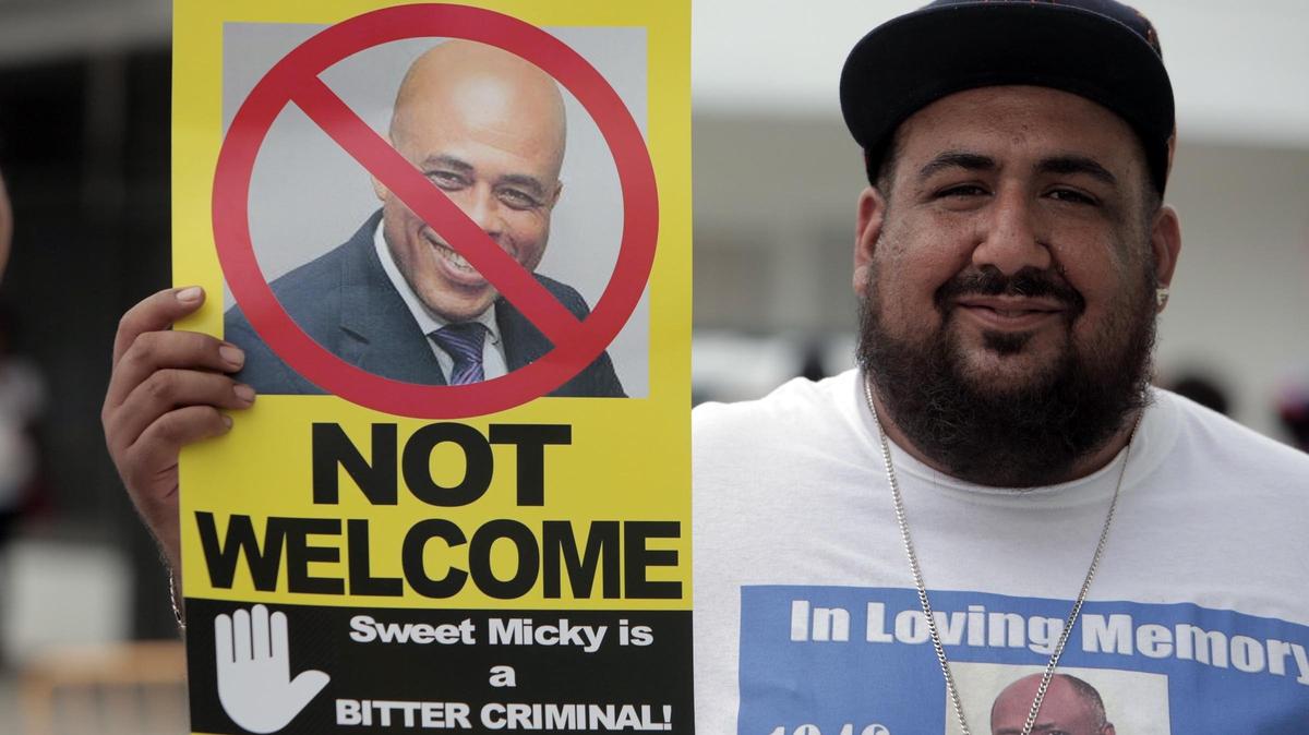 Michael Martinez of the Labor Community Alliance of South Florida protests the appearance of Michel Martelly during Haitian Flag Day Celebration at the Little Haiti Cultural Center Complex on Friday.