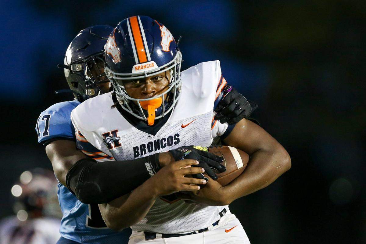 Homestead Broncos quarterback Joshua Townsend (3) run with the football as Palmetto Panthers Willis McGahee IV (17) attempts a tackle during the second quarter of a high school football game at Tropical Park Stadium in Miami, Florida, Thursday, August 25. 2022.