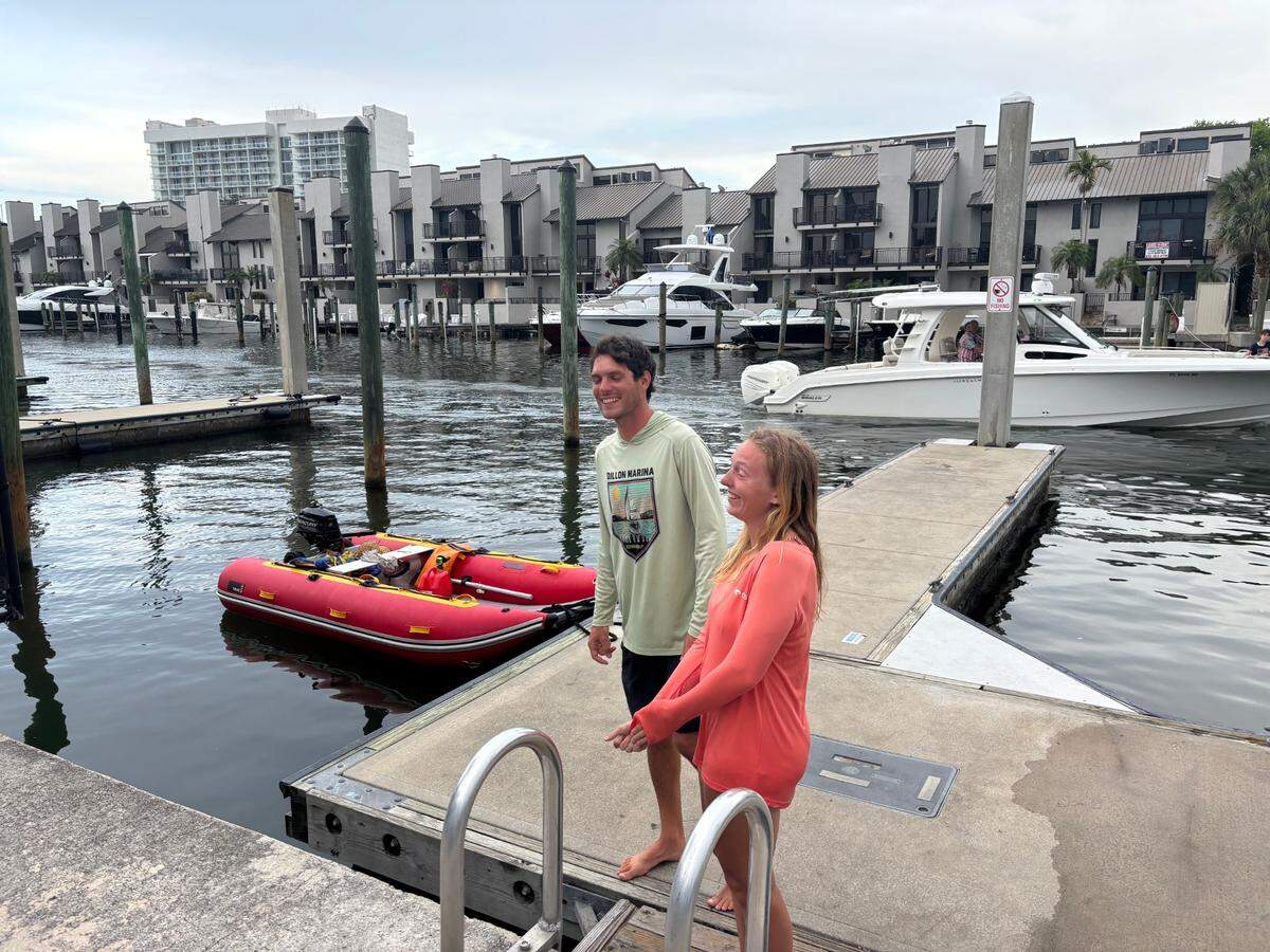 Bret Triano and Marisa Toomsen describe how they jumped into action to rescue a man after the boat he was on exploded in the Intracoastal Waterway in Fort Lauderdale on Monday, May 26, 2025. Triano and Toomsen brought the man to shore on the red dinghy pictured behind them.
