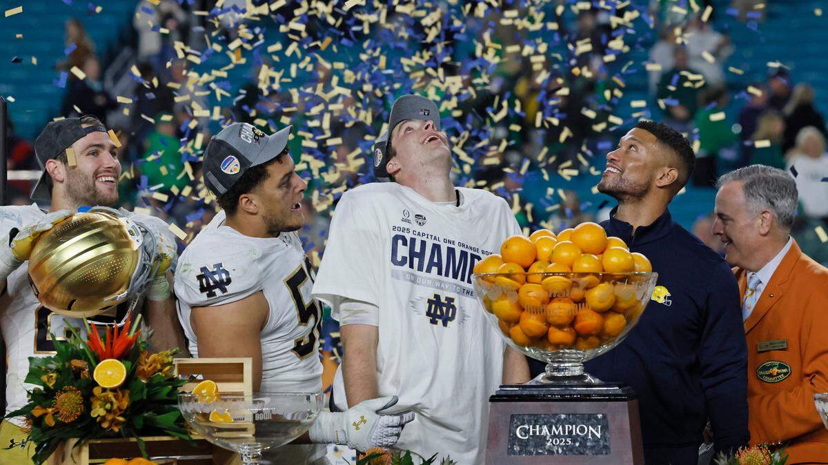 Notre Dame Fighting Irish running back Jadarian Price (24), offensive lineman Charles Jagusah (56) quarterback Riley Leonard (13), and head coach Marcus Freeman watch the confetti drop after defeating Penn State Nittany Lions in their NCAA Playoff Semifinal Capital One Orange Bowl football game at Hard Rock Stadium in Miami Gardens, Florida on Thursday, January 9, 2025.