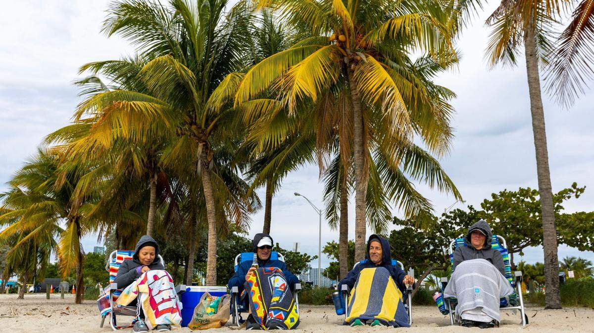 A group of runners take their traditional post-run snack break at Key Biscayne Dog Beach in Miami, Florida, on Saturday, December 24, 2022.