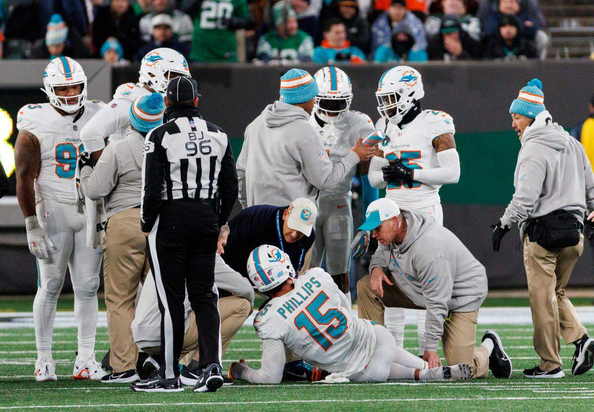 Miami Dolphins linebacker Jaelan Phillips (15) is being treated by team medical personnel after getting injured in a play during fourth quarter of an NFL football game against the New York Jets at MetLife Stadium on Friday, Nov. 24, 2023 in East Rutherford, New Jersey.