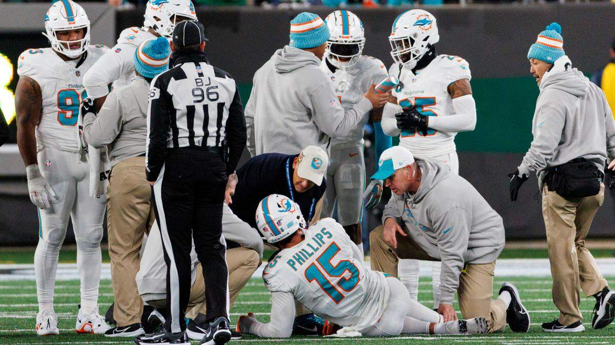 Miami Dolphins linebacker Jaelan Phillips (15) is being treated by team medical personnel after getting injured in a play during fourth quarter of an NFL football game against the New York Jets at MetLife Stadium on Friday, Nov. 24, 2023 in East Rutherford, New Jersey.