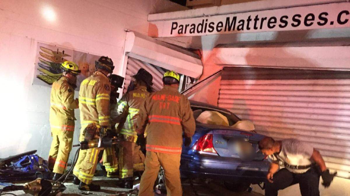 Miami-Dade firefighters work a scene after a car crashed into a mattress store.