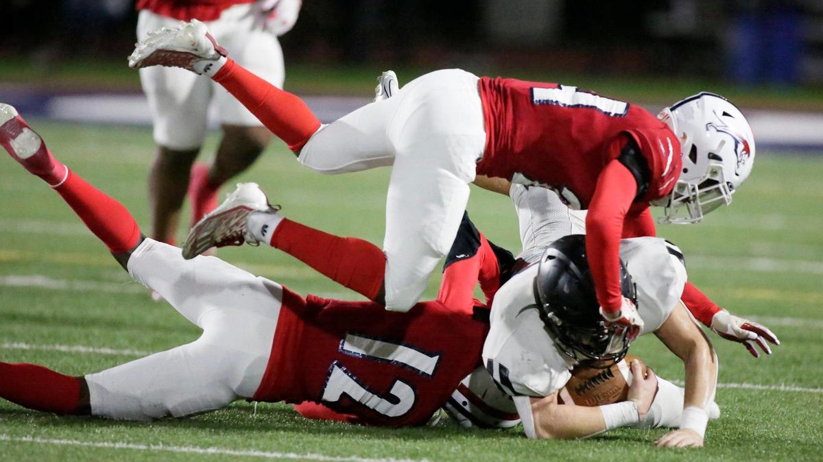 Chaminade-Madonna Lions defenders take down Archbishop Carroll Bulldogs ball carrier during the state semifinal football game on Friday, December 1, 2023 at Chaminade-Madonna School in Hollywood. Andrew Uloza / for Miami Herald