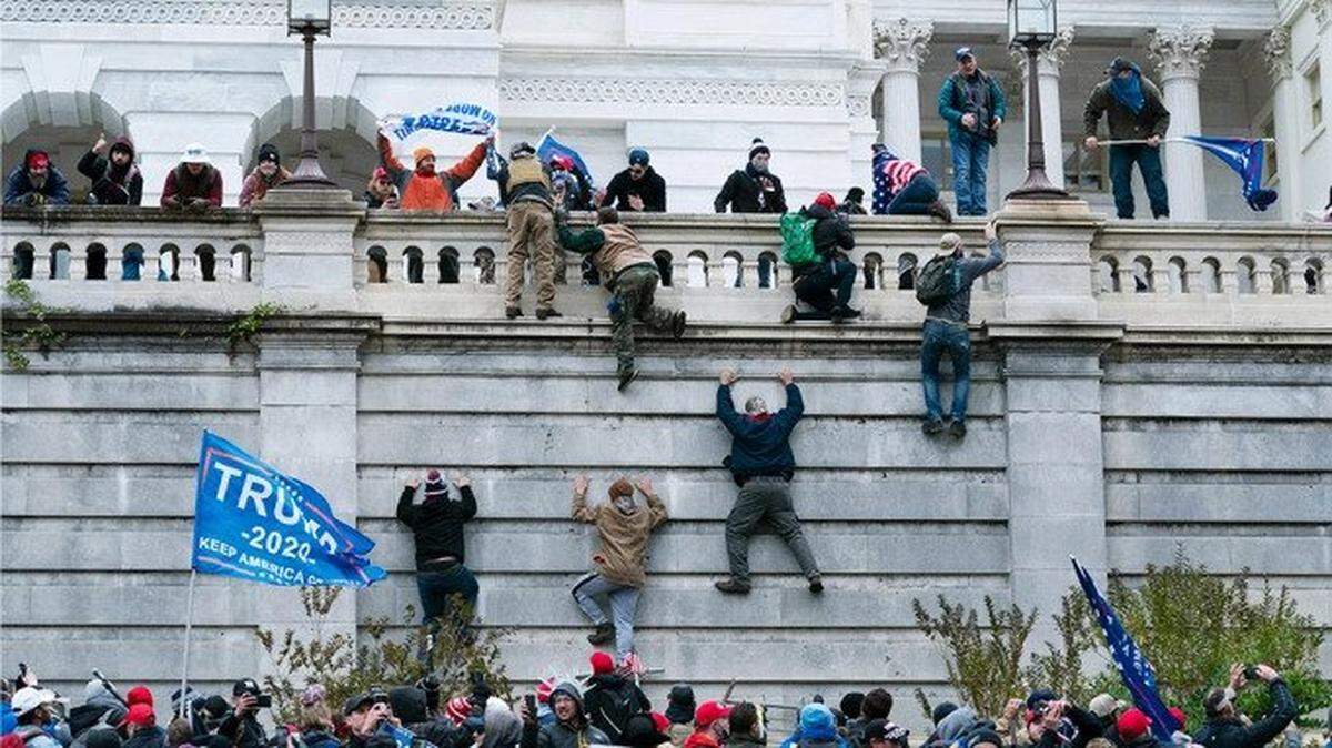 Rioters climb the outside walls of the U.S. Capitol riot on Jan. 6, 2021.