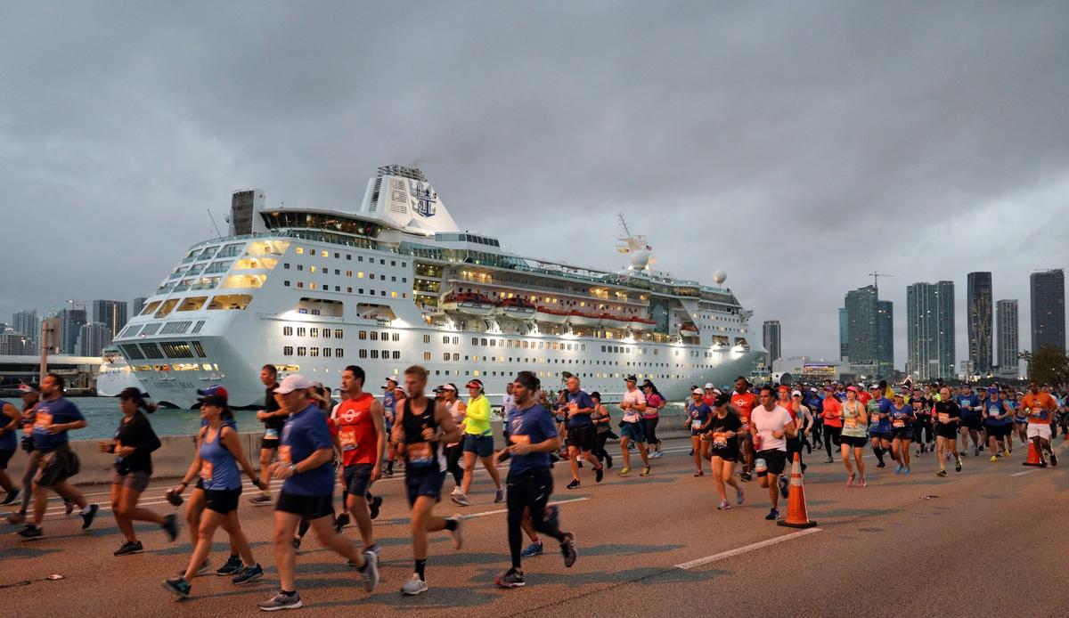Runners head eastbound on the MacArthur Causeway as the Royal Caribbean cruise ship, Empress of the Seas, enters Government Cut to dock at the Port of Miami.  On Sunday, January 27, 2018 thousands of athletes - pushrim, handcycle, and assisted wheelchair, elite, and daily runners participated in the 2019 Fitbit Miami Marathon and Half Marathon.  The full course spanned across the Venetian, Rickenbacker, and MacArthur Causeways ending at Bayfront Park in downtown Miami, Florida.