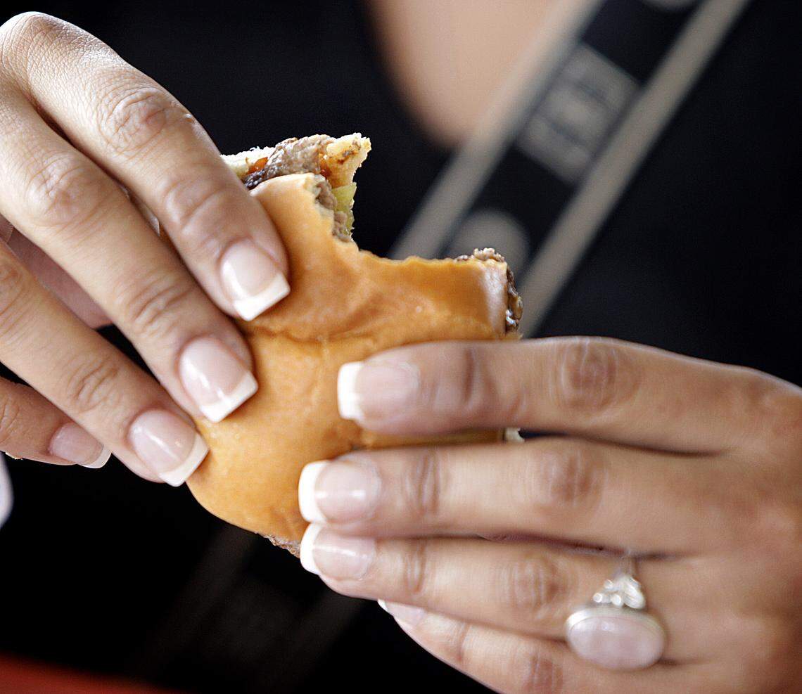 1/16/08 Patrick Farrell/Miami Herald A customer bites into one of those famous burgers at the last Royal Castle.