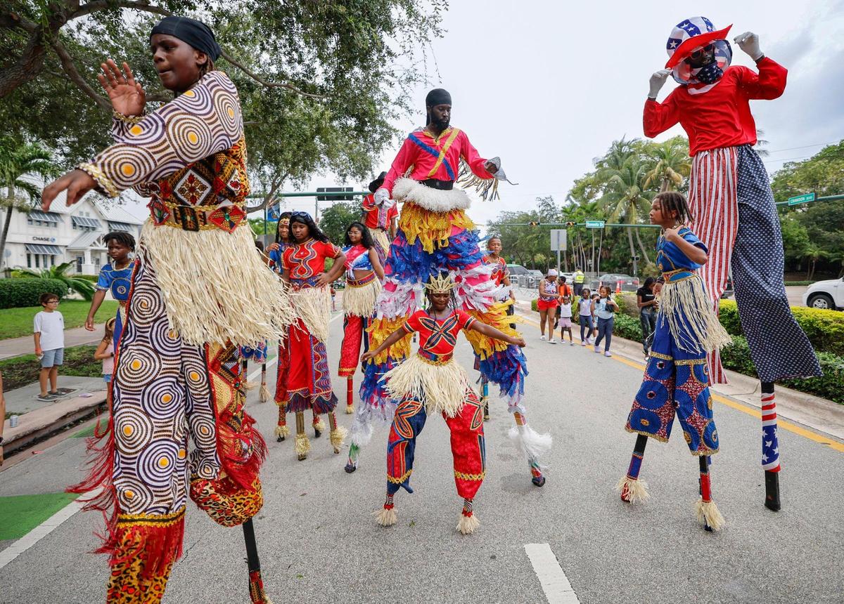 Stilt dancers dance along Crandon Bouldevard as residents, family and friends celebrate Independence Day during the 66th Annual Key Biscayne Fourth of July Parade on Key Biscayne, Florida on Friday, July 4, 2025.