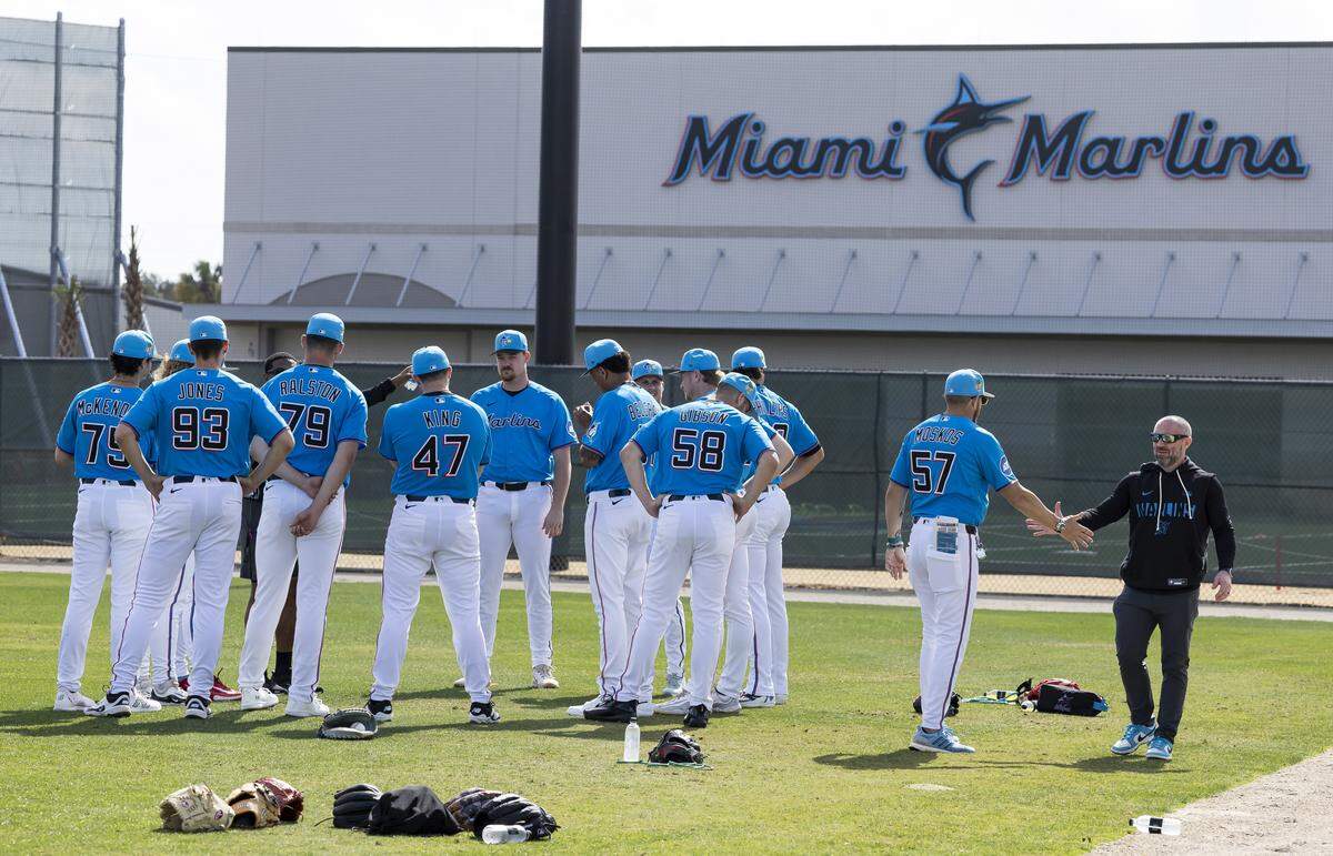 Miami Marlins players huddle during the team's first full-squad spring training workout at Roger Dean Stadium on Monday, Feb. 16, 2026, in Jupiter, Fla.