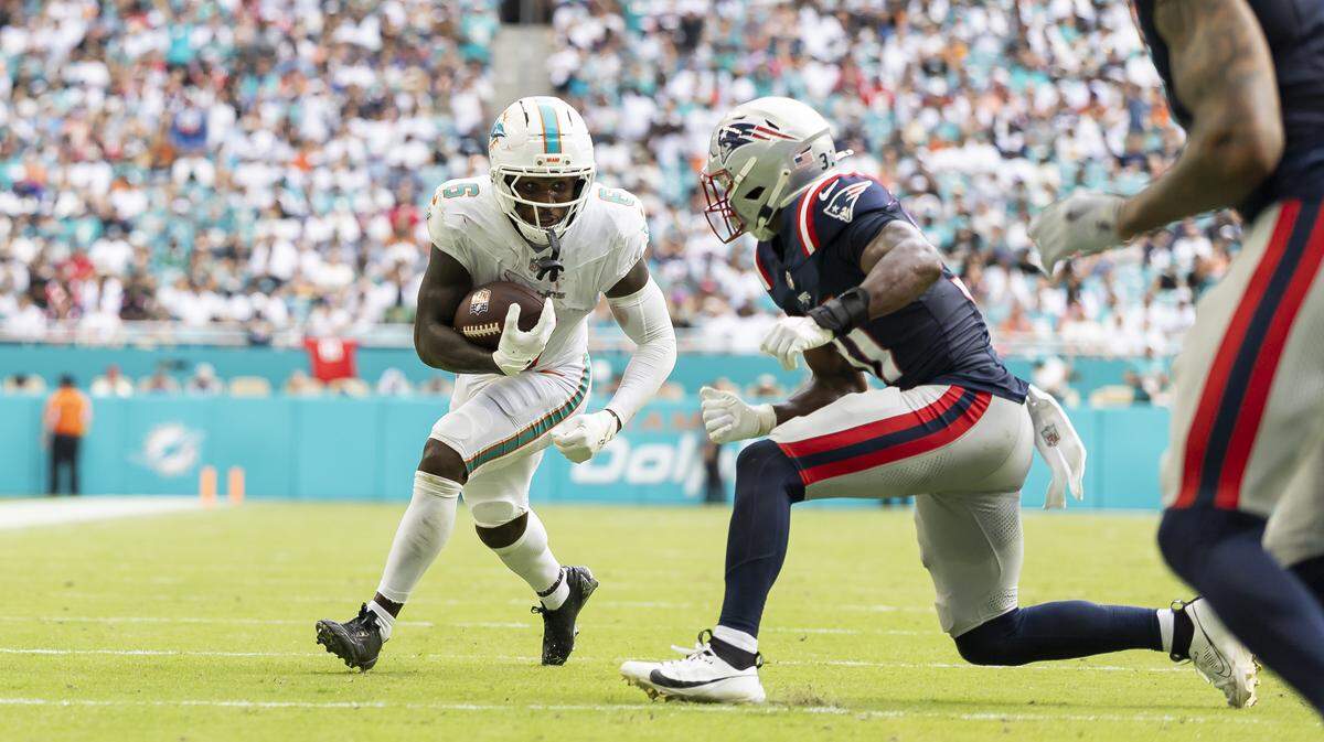 Miami Dolphins wide receiver Malik Washington (6) runs with the ball as New England Patriots safety Craig Woodson (31) goes for the tackle in the second half of their NFL game at Hard Rock Stadium on Sunday, Sept. 14, 2025, in Miami Gardens, Fla.