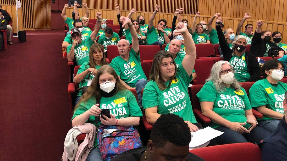 Residents opposed to a residential development on the shuttered Calusa golf course near their homes signal their disapproval during the Wednesday, Nov. 17, 2021, meeting of the Miami-Dade County Commission to vote on the project’s zoning approval.