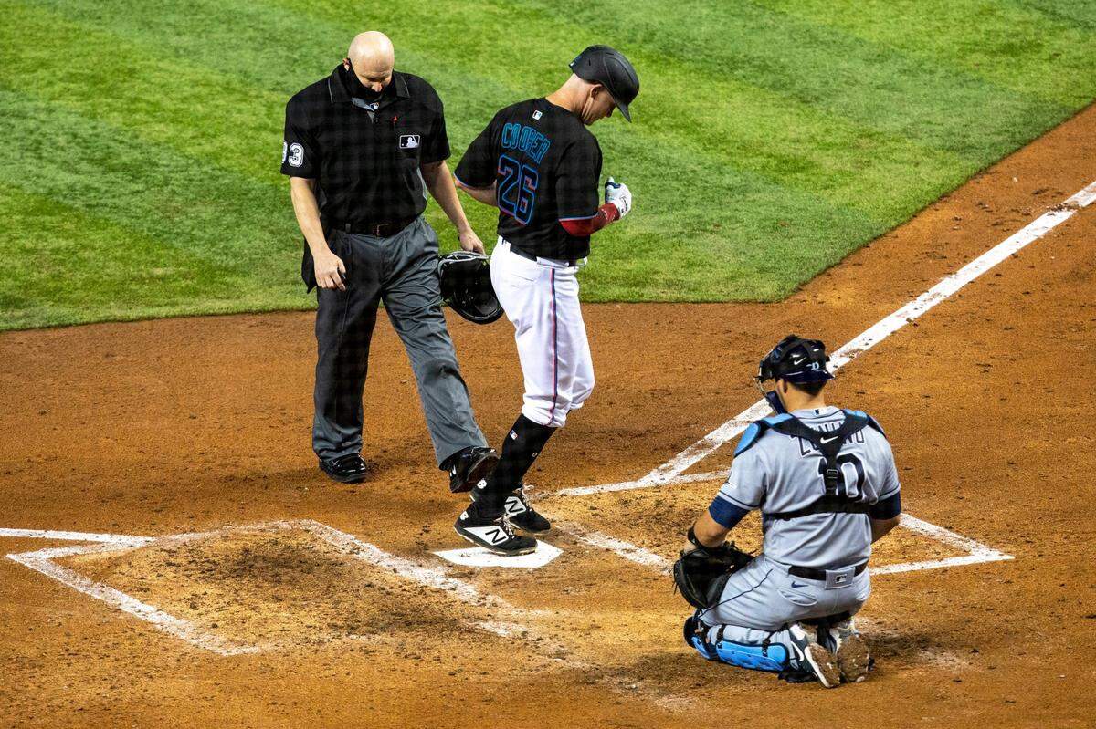 Miami Marlins Garrett Cooper&nbsp;(26) crosses home plate after homering during the third inning of an MLB game against the Tampa Bay Rays at loanDepot park in the Little Havana neighborhood of Miami, Florida, on Saturday, April 3, 2021. 