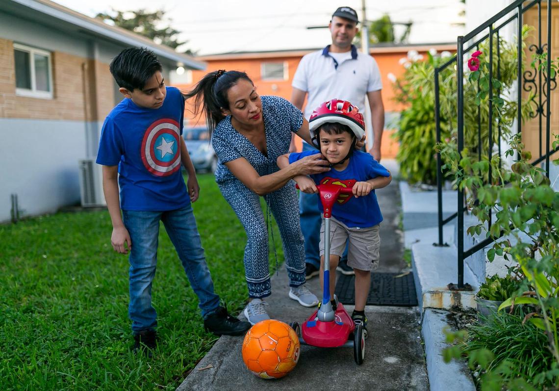 From left, Juan David Acuna, 12, Ana Alvarez, 47, Juan Ramon Acuna, 44, and Mateo Acuna, 5, spend time together outside their home in Hialeah. Alvarez lost her job cleaning homes in Miami Beach due to the coronavirus pandemic and has since stayed home with the kids.