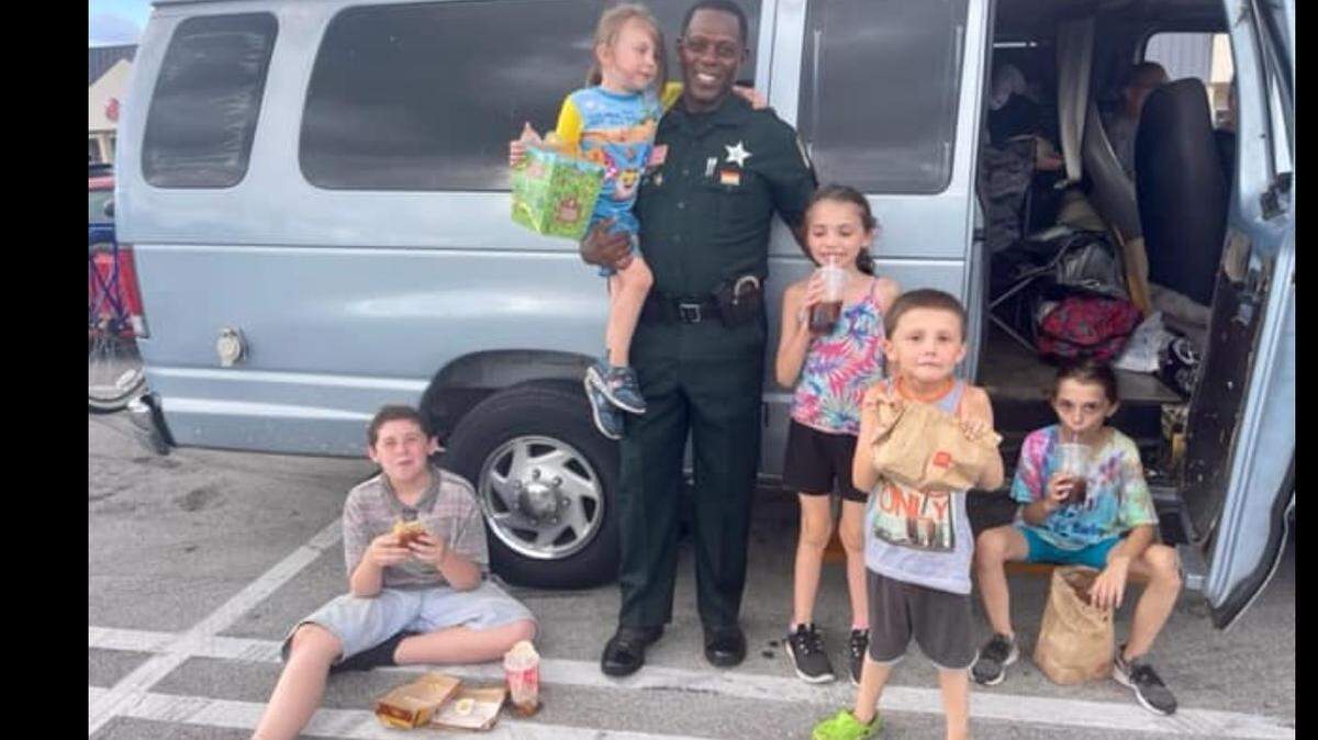 Deputy Kenneth Torrence with the Palm Beach Sheriff' Office with a family he met at an Office Depot in Lake Worth