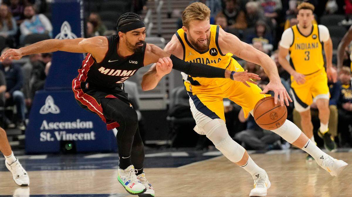 Indiana Pacers forward Domantas Sabonis, right, and Miami Heat’s Gabe Vincent reach for the ball during the second half of an NBA basketball game in Indianapolis, Friday, Dec. 3, 2021. (AP Photo/AJ Mast)