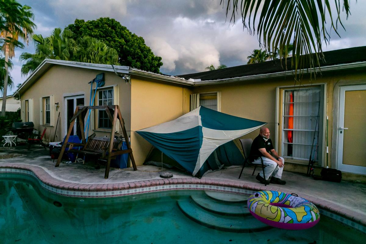 John Delgado, 52, drinks a beer while waiting for it to get dark at his home in Homestead. Delgado is living in a tent in his backyard to avoid the possibility of infecting his family with the coronavirus.