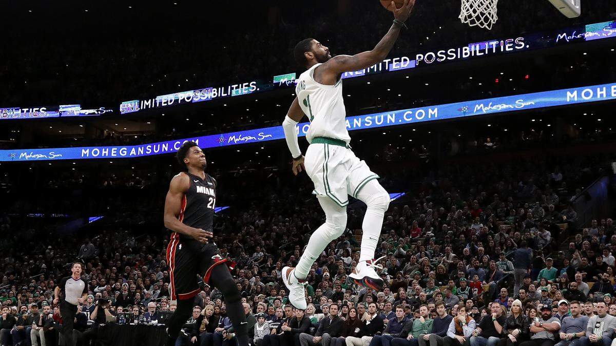 Boston Celtics’ Kyrie Irving, right, goes in for a layup past Miami Heat’s Hassan Whiteside during the second quarter of an NBA basketball game Monday, Jan. 21, 2019, in Boston. (AP Photo/Winslow Townson)