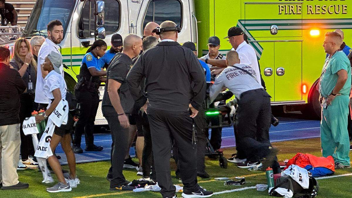 An high school football player from American Heritage School in Plantation is attended to by paramedics shortly after he collapsed during a game Friday night against Miami Booker T. Washington at Traz Powell Stadium in north Miami.