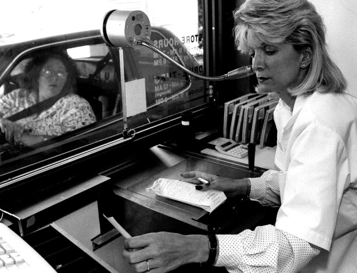 Angela Mann, owner of Carl’s Discount Pharmacy in Coral Springs, works the drive-through window in 1993.