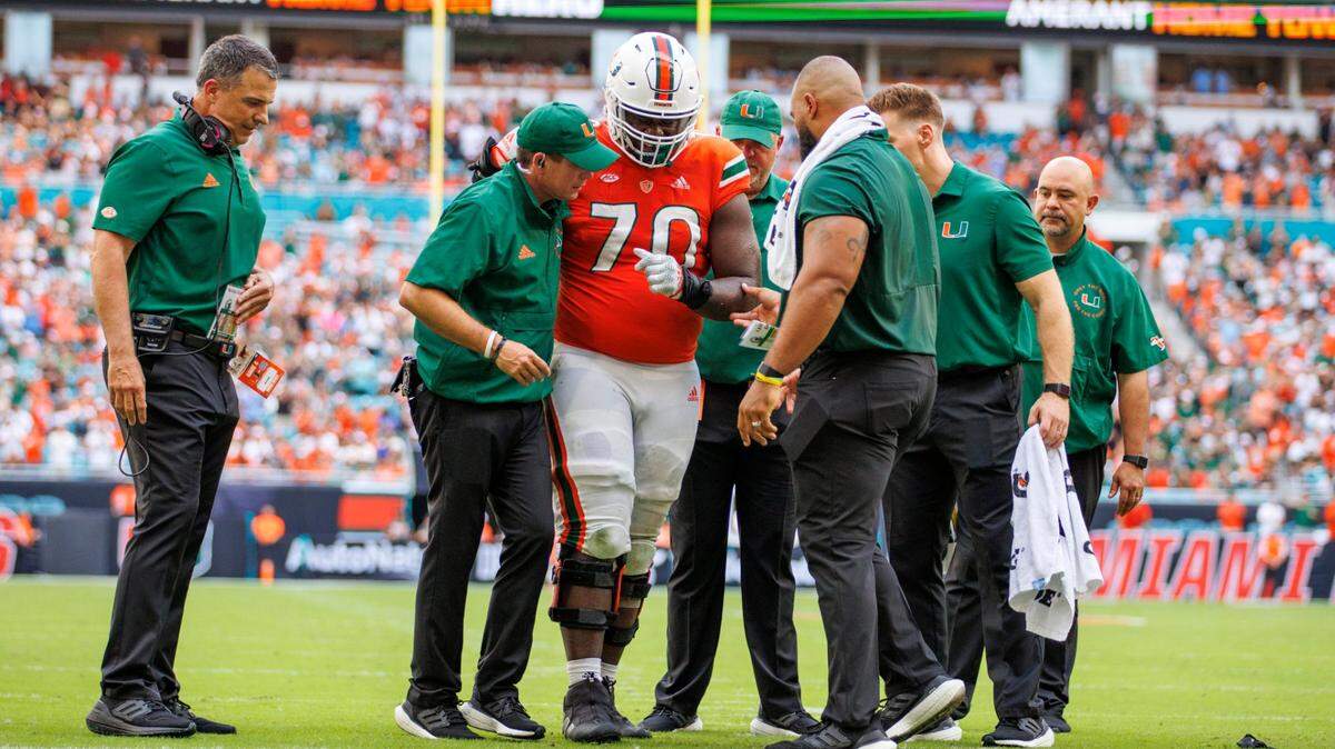 Miami Hurricanes offensive lineman Justice Oluwaseun (70) walk off the field after injured in a play during the second quarter of an ACC conference football game against North Carolina Tar Heels at Hard Rock Stadium on Saturday, October 8, 2022 in Miami Gardens, Florida..