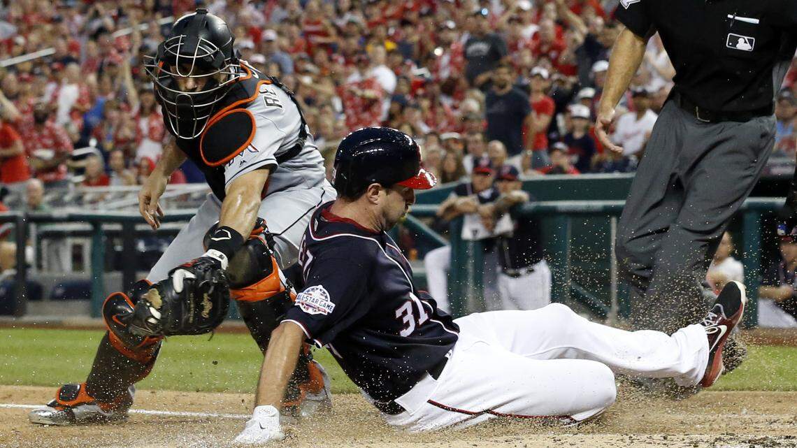 Miami Marlins catcher J.T. Realmuto can’t make the tag on Washington Nationals’ Max Scherzer, who is safe at home on the single by Bryce Harper during the third inning of a baseball game at Nationals Park, Friday, Aug. 17, 2018, in Washington. (AP Photo/Alex Brandon)