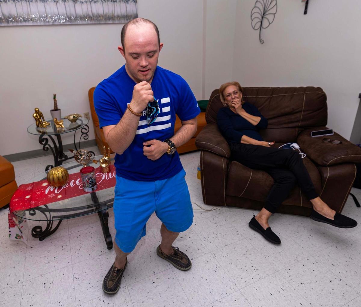 Eduardo Perez, who has Down syndrome, dances with grace and infectious energy as his mother, Xiomara Gonzalez, watches in their home in Hialeah.