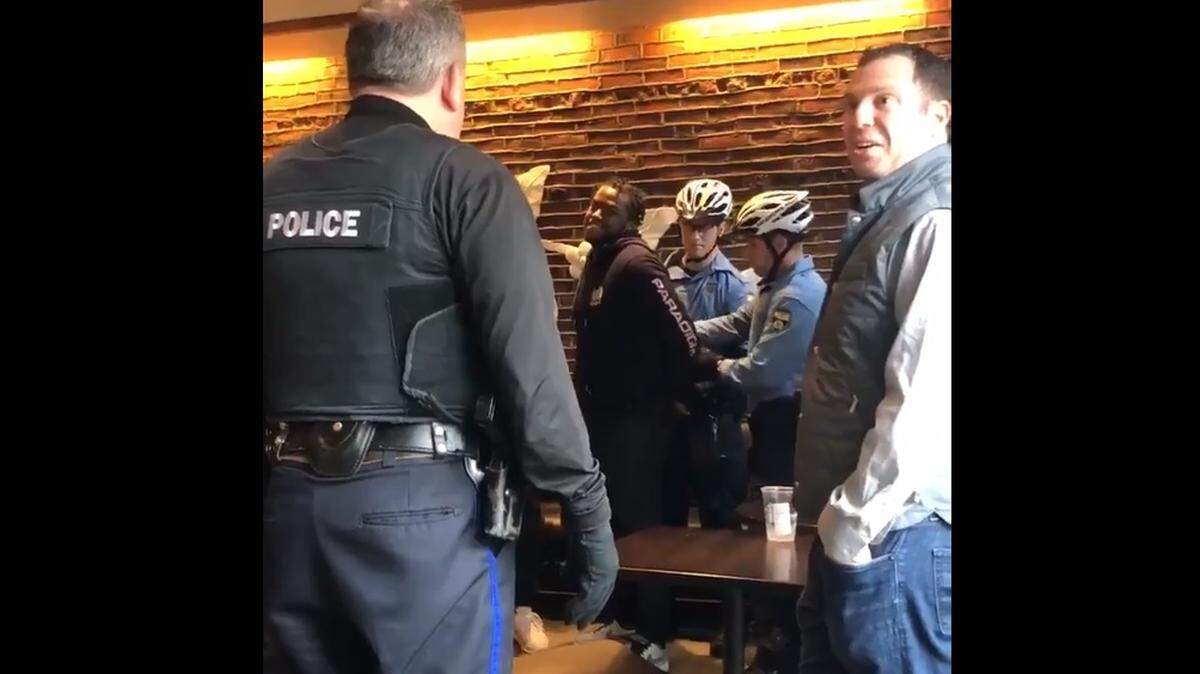 A screen grab of a video posted on Twitter shows police arresting two black men after Starbucks said they attempted to use a restroom inside the store and then refused to leave. Critics are calling the incident "racist."