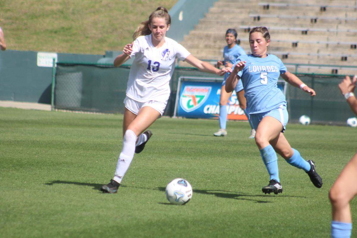 Lourdes’ Coco Aguilar (5) battles Fletcher forward Sawyer Reynolds for a loose ball during Friday afternoon’s Class 6A state final at Spec Martin Stadium in DeLand.
