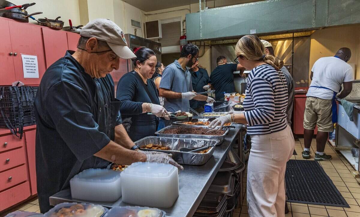 Adam Snitzer (far left) packs food into containers before Nourish Miami’s breakfast service at the Greater Bethel African Methodist Episcopal Church in Overtown, Miami, on Friday, June 5, 2026.
