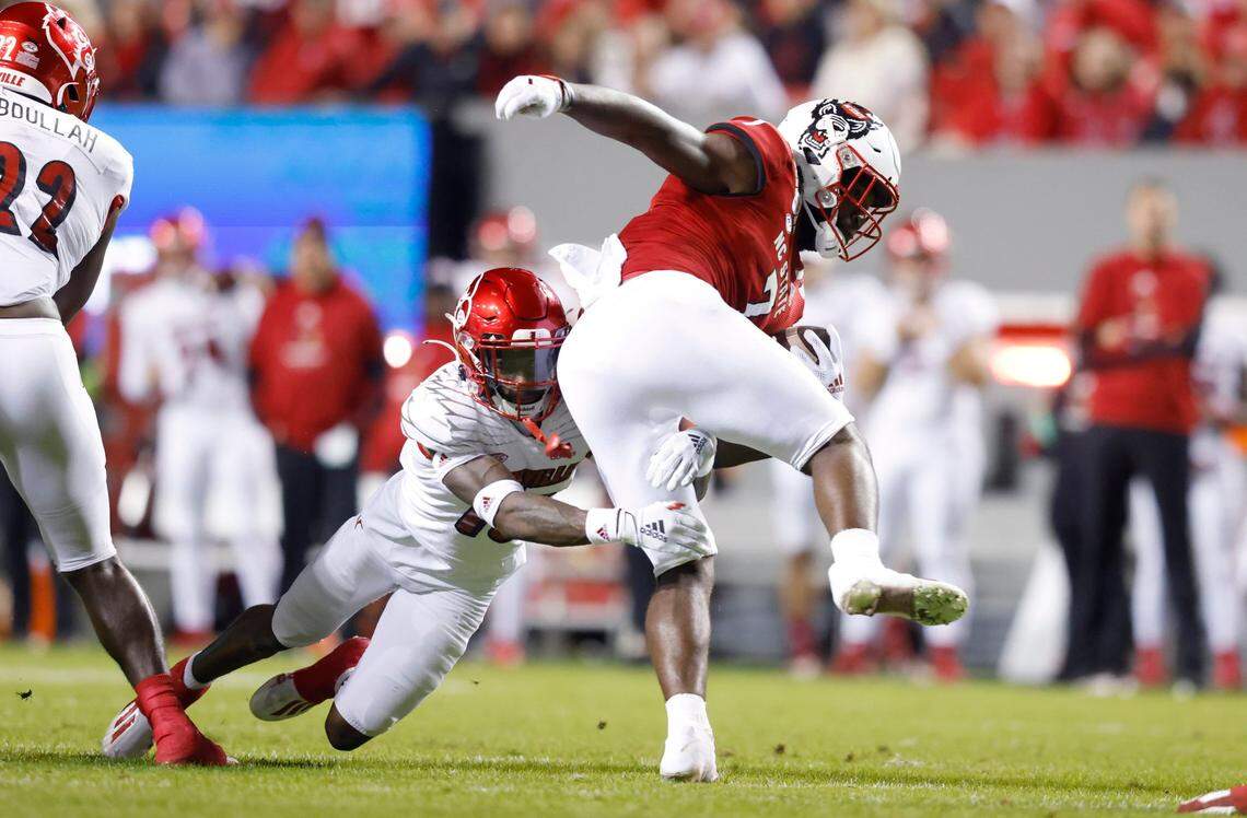 N.C. State running back Zonovan ‘Bam’ Knight (7) tries to break free from Louisville defensive back Kei’Trel Clark (13) during the first half of N.C. States game against Louisville at Carter-Finley Stadium in Raleigh, N.C., Saturday, October 30, 2021.