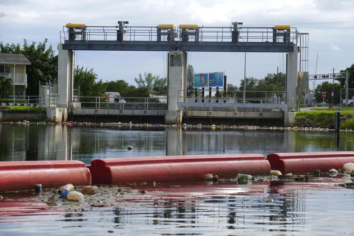 An orange boom used to collect garbage and debris stretches across the Little River just north of the South Florida Water Management District’s flood control structure near Northeast 82nd Street and Northeast Fourth Place.