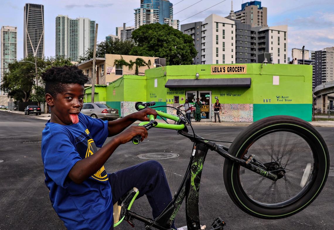 Zion Cooper, 10, rides his bike on the corner of Northwest First Place and Northwest 11th Street on May 14, 2019. Old storefronts and apartment buildings are dwarfed by new development as gentrification takes root in Miami’s historic Overtown neighborhood.