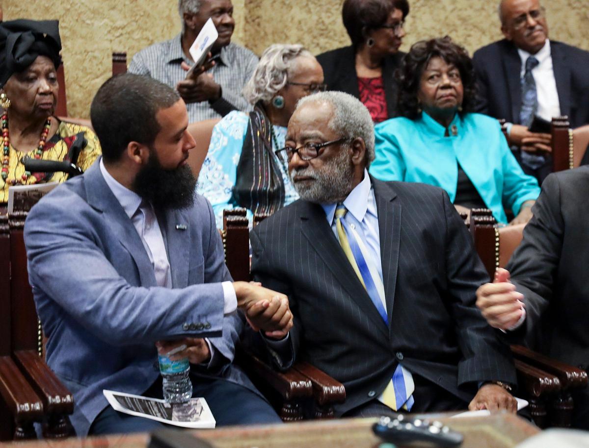 Keynote speaker William Snowden, left, and Miami attorney H.T. Smith shake hands after Snowden gave his presentation on racial bias. Smith led the movement to create a bust of the late Honorable John D. Johnson, the second black judge in Miami-Dade County and the fourth in Florida.