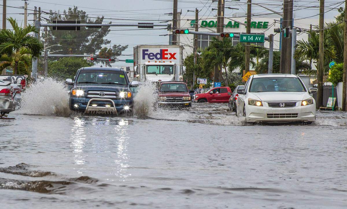 Cars drive through the flood at West 29th Street and 14th Avenue in Hialeah as torrential downpours inundate South Florida due to a disturbance off Florida’s coast on Thursday, November 16, 2023.