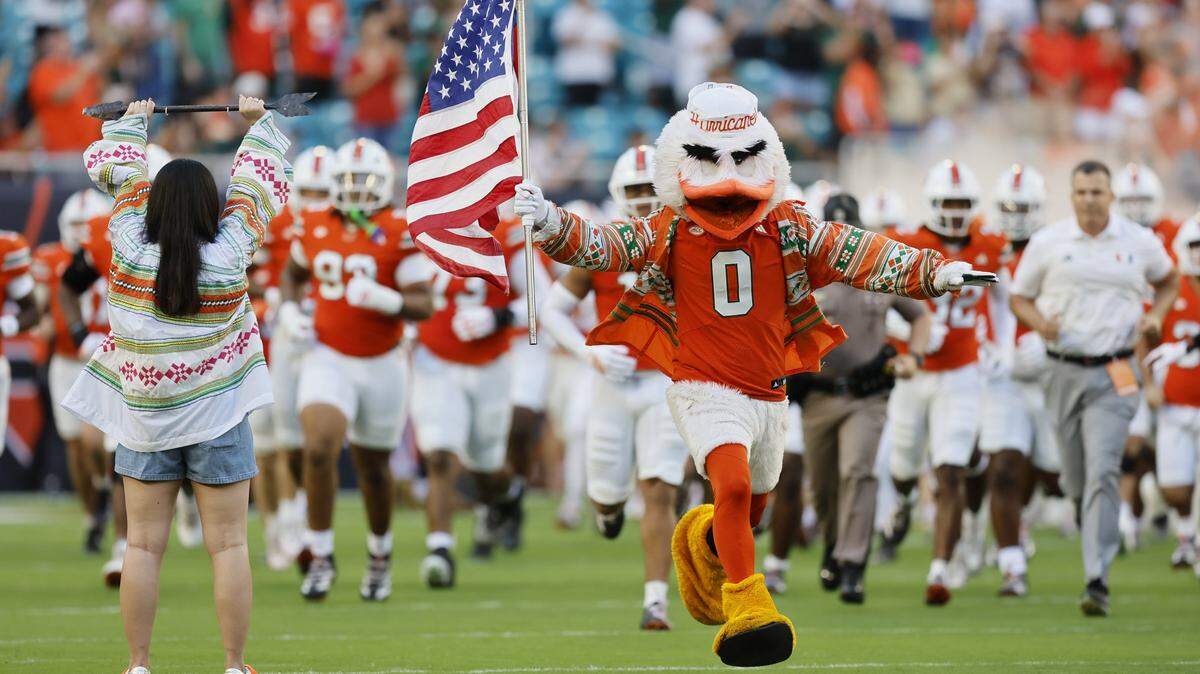 Miami Hurricanes charge the field for the start of an NCAA football game against the Syracuse Orange at Hard Rock Stadium in Miami Gardens, Florida on Saturday, November 8, 2025. 