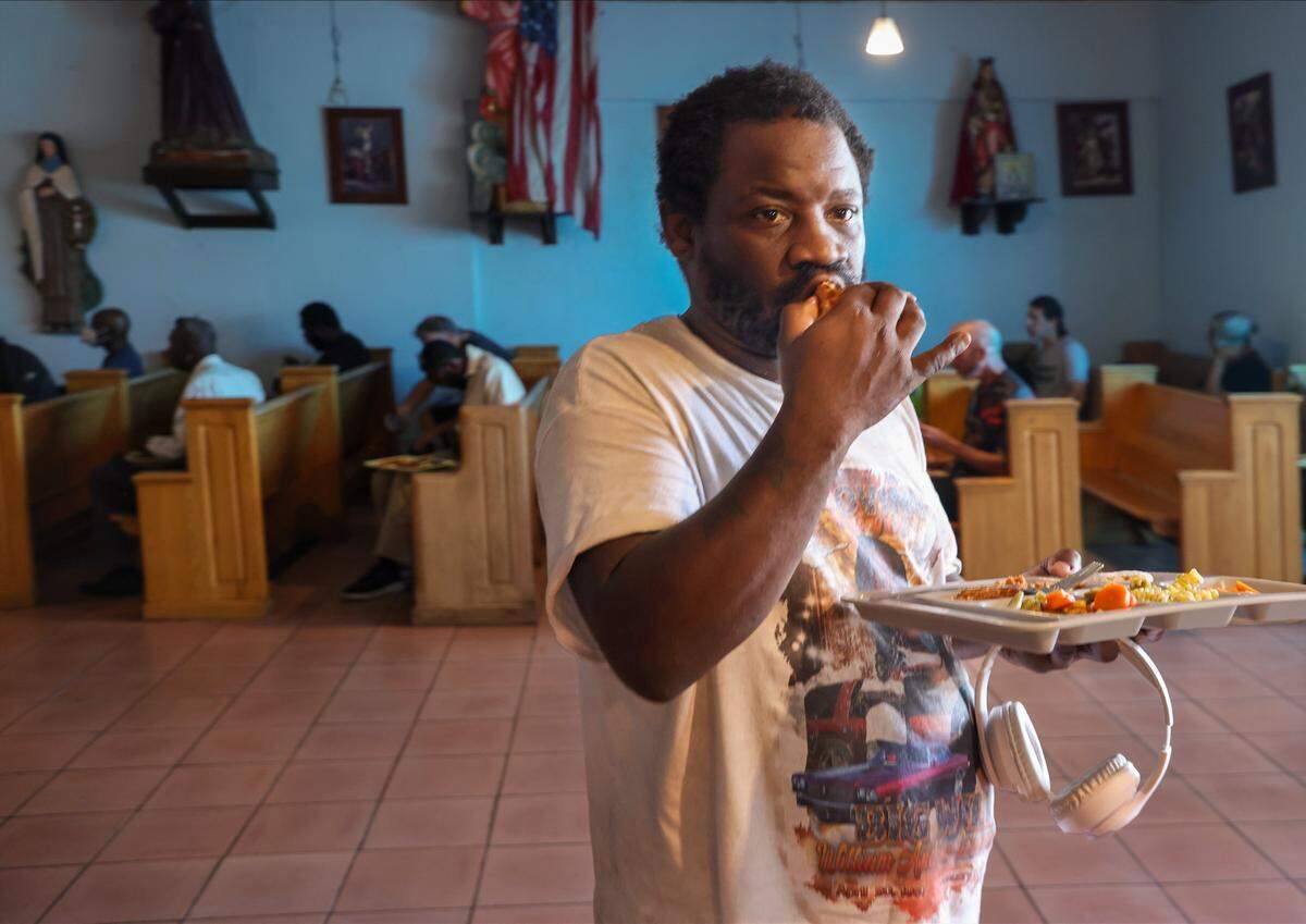 People experiencing homelessness enjoy a warm lunch at the gather at All Saints Catholic Mission in Oakland Park, Florida on Monday, January 26, 2026. Father Bob Caudill at All Saints Catholic Mission in Oakland Park fed the homeless every day, despite city officials claiming it was against the rules. The city fined him $150 each day since 2016. He sued the city for religious discrimination. The trial was set to begin soon.